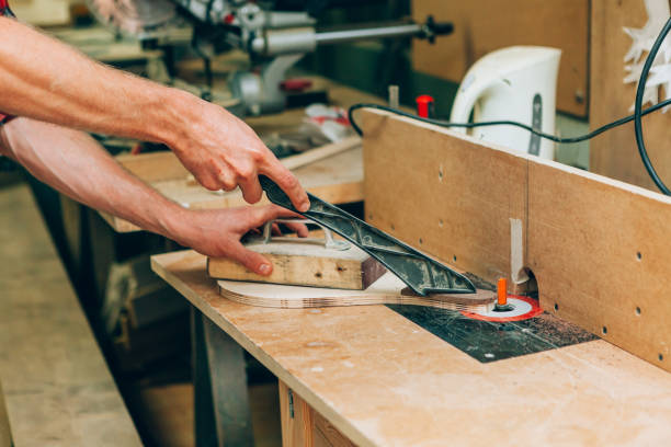 Hands operating woodworking machine in furniture manufacturing unit