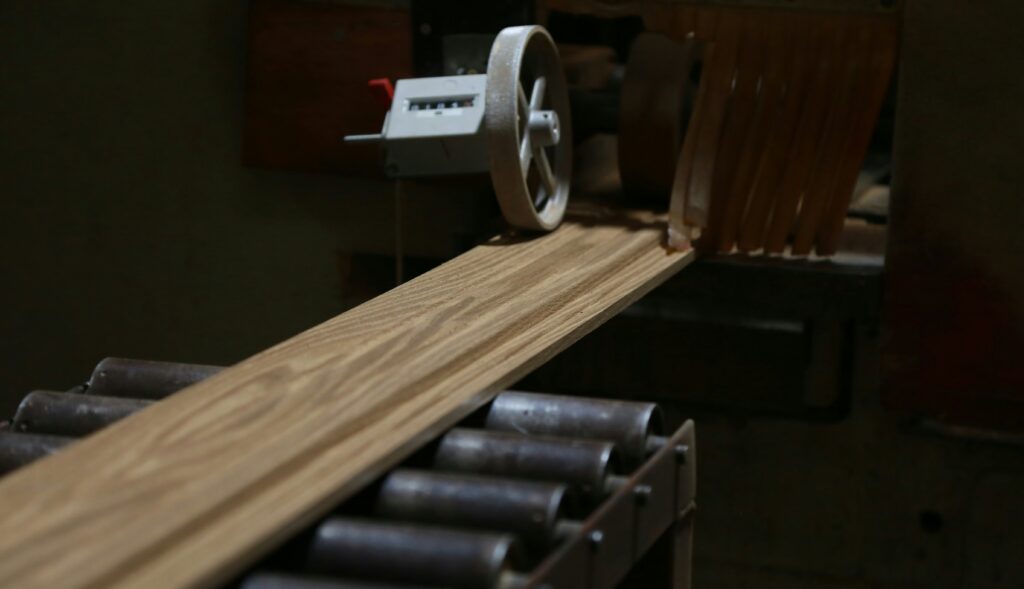 Automated plywood cutting machine processing wooden boards in a modern manufacturing setup